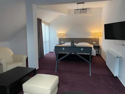 a room with a bed and a desk and a tv at Urban 7 Residence in Bucharest