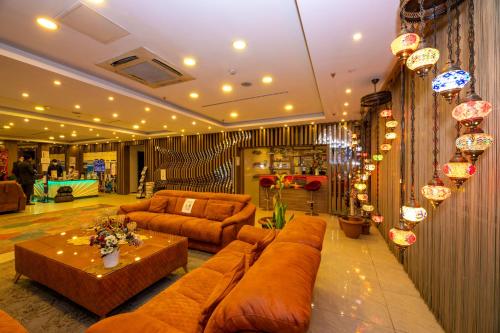 uma sala de estar com sofás castanhos e uma mesa em Grand Palace Hotel em Istambul