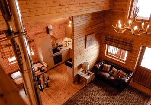 einen Blick über ein Wohnzimmer und eine Küche in einem Blockhaus in der Unterkunft Pentland Lodge in Gorebridge