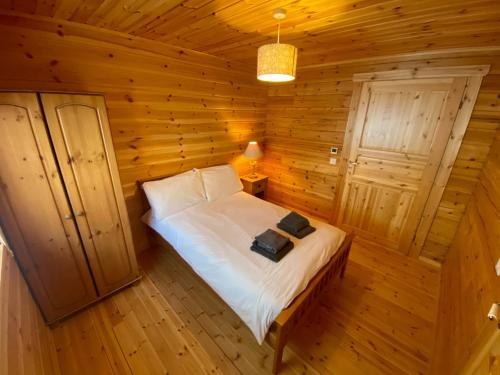 a bedroom with a bed in a log cabin at Pine Lodge in Gorebridge