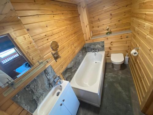 a bathroom with a tub and a sink and a toilet at Pine Lodge in Gorebridge