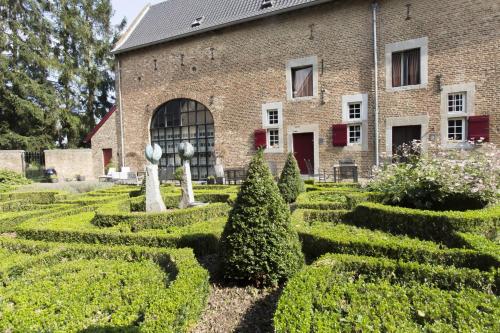 a garden in front of a brick building with bushes at Meschermolen 13 in Eijsden