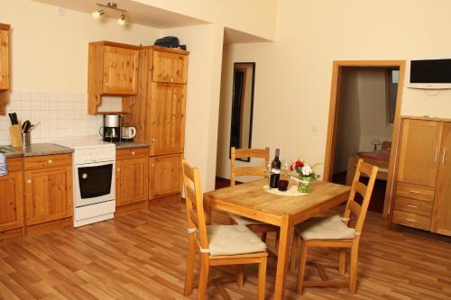 a kitchen with a wooden table and wooden chairs at Pension Ferienhof Fischer in Freiberg