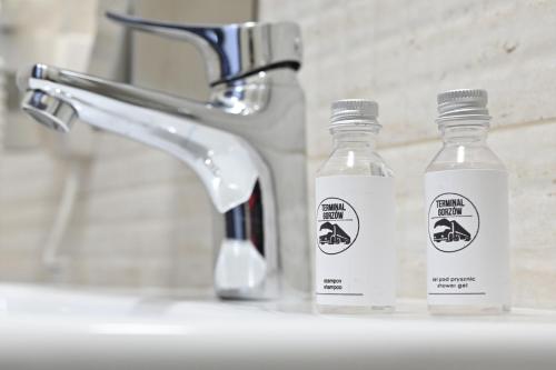 dwie butelki wody siedzące obok umywalki w łazience w obiekcie Hotel Terminal w mieście Gorzów Wielkopolski