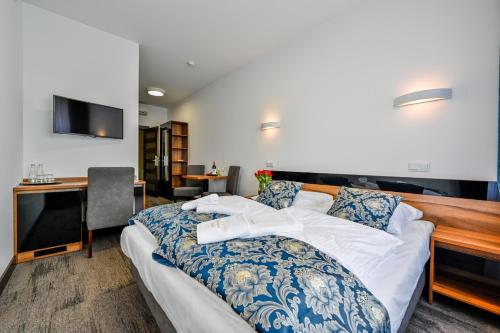 Dormitorio con cama, escritorio y TV en Hotel Terminal en Gorzów Wielkopolski