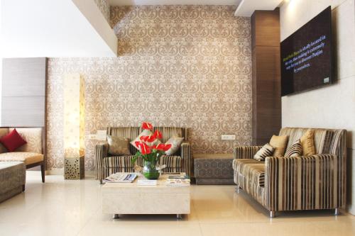 a lobby with two couches and a table with flowers at Hotel Park Plaza in Panaji