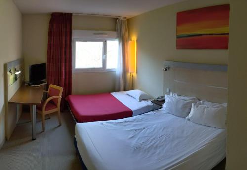a hotel room with two beds and a desk at Le Domaine des Fontaines - Hôtel & Petit Déjeuner in Bernin