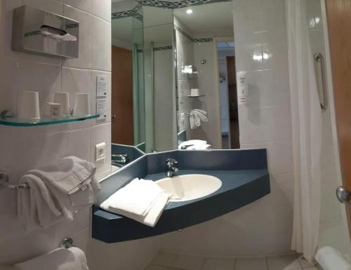 La salle de bains est pourvue d'un lavabo et d'un miroir. dans l'établissement Le Domaine des Fontaines - Expérience, à Bernin