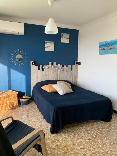une chambre avec un lit et un mur bleu dans l'établissement Canet Plage Appartement Cosy très calme, à Canet
