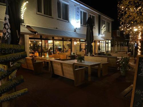 a restaurant with wooden tables in front of a building at Hotel Restaurant Anno Nu in Oostkapelle