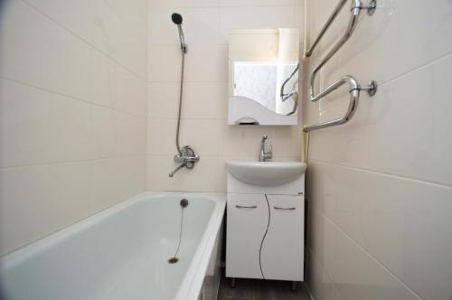 een badkamer met een wastafel, een bad en een toilet bij Мода в доме 14 in Oral