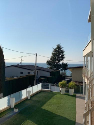 a balcony with a yard of grass and plants at Hotel Villa Katy in Bardolino