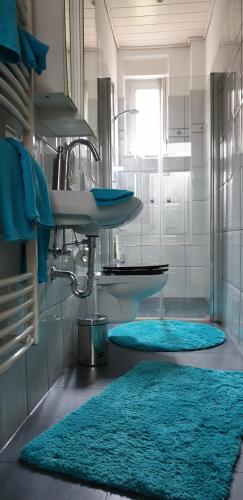 a bathroom with blue rugs on the floor and a sink at Angela in Baden-Baden