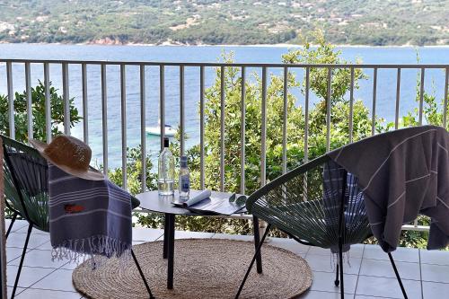 a table and chairs on a balcony with a view of the water at Hôtel Sampiero in Propriano