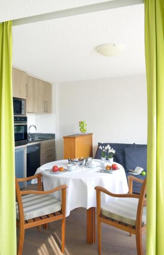 a kitchen with a table and two chairs and a kitchen with a table at Résidence Le Vénète in Le Croisic