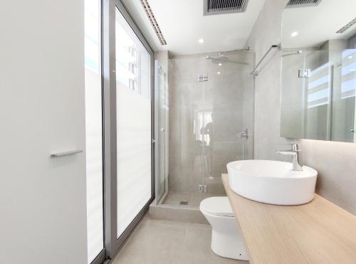 a white bathroom with a sink and a toilet at Verde Apartments in Athens