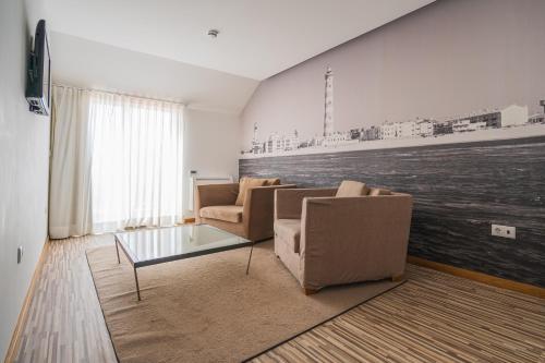 a living room with two chairs and a coffee table at Hotel Farol in Praia da Barra