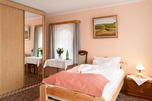 1 dormitorio con cama, mesa y espejo en Haus Waldheim, en Malente