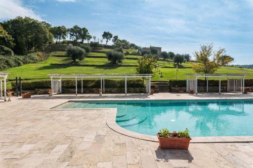a swimming pool with a gazebo and a field at Gilda in Roccalbegna