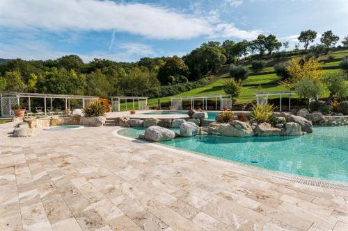 an outdoor swimming pool with rocks in a yard at Gabriele in Roccalbegna