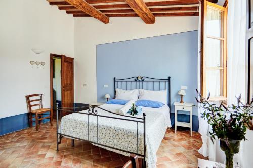 a bedroom with a large bed with blue walls at Agriturismo Lunadoro in Monticchiello