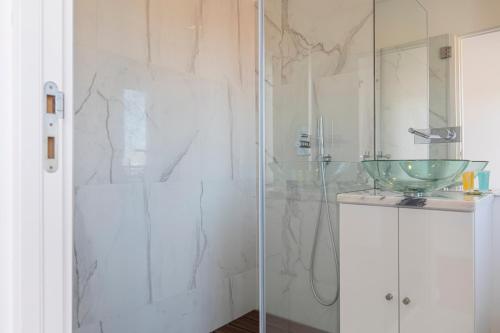 een badkamer met een glazen douche en een glazen wastafel bij Classy Two Bedroom View in Lissabon