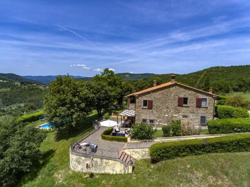 una vista esterna di una casa in pietra con piscina di Villa il Sole a Civitella in Val di Chiana
