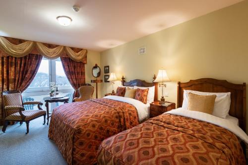 a hotel room with two beds and a window at Earls Court House in Killarney