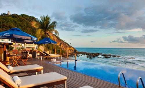 a resort infinity pool with the ocean in the background at Pousada Bahia Bacana in Morro de São Paulo