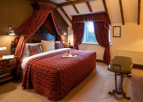 a bedroom with a large bed with a red blanket at Earls Court House in Killarney