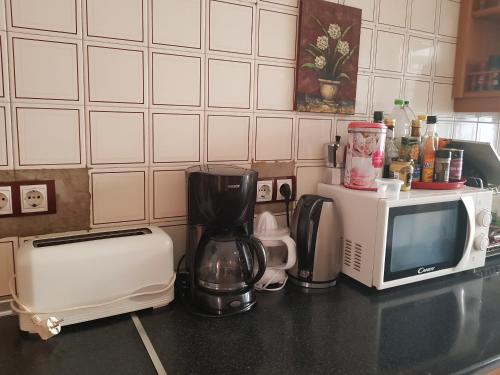 a kitchen counter with a microwave and a coffee maker and a toaster at laurainu in Puerto del Rosario