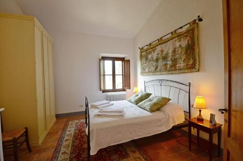 - une chambre avec un lit et une peinture murale dans l'établissement Casa del Vignaiolo, à Gaiole in Chianti