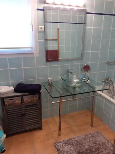 a bathroom with a glass sink and a mirror at frederique lavande bleue in Le Luc