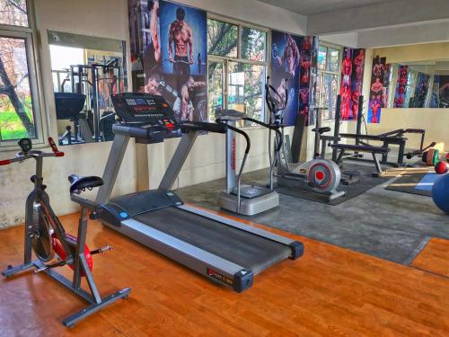 a gym with several exercise equipment in a room at Highland Village Resort in Dharmsala