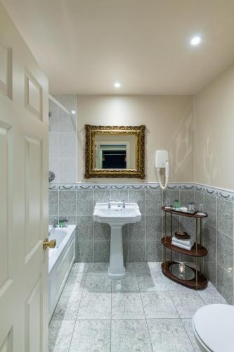 a bathroom with a sink and a toilet and a tub at Earls Court House in Killarney