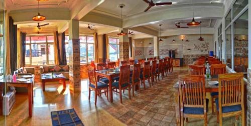a dining room with wooden tables and chairs at Highland Village Resort in Dharmsala