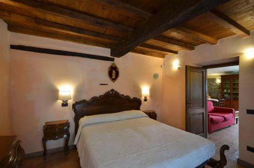 a bedroom with a large bed and a pink couch at Il Tiglio in Orvieto