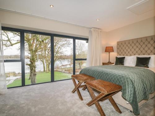 a bedroom with a bed and a large window at Tarn End Cottages 8 in Brampton