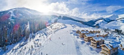 a snow covered mountain with a ski lodge and a ski slope at Chalet Jasná Wellness Apartment Maxim jacuzzi & sauna in Demanovska Dolina