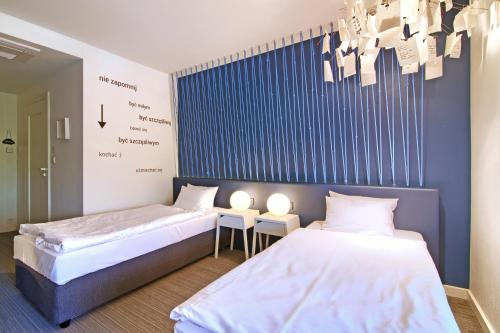 two beds in a room with blue and white at Pałac Pakosław in Pakosław