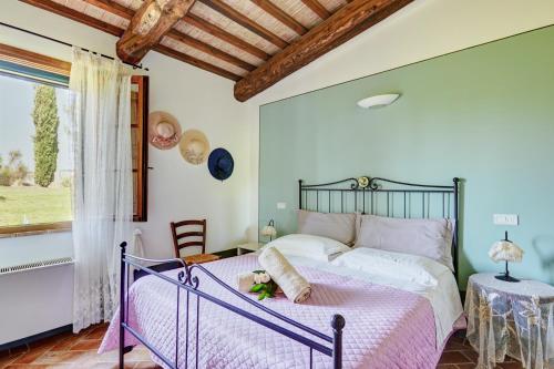 a bedroom with a bed and a table and a window at Agriturismo Lunadoro in Monticchiello
