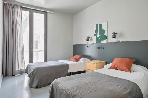 バルセロナにあるMy Address in Plaza Realのベッドが2つと窓のある部屋