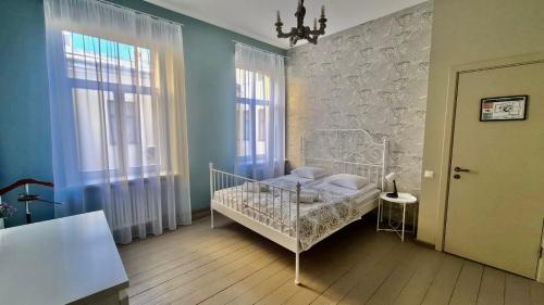 um quarto com uma cama branca e 2 janelas em Blue Bird Hostel in Riga Old Town em Riga