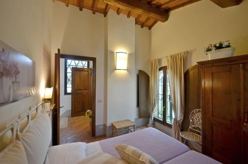 a bedroom with a white bed and a wooden cabinet at La Capannina in Le Grazie