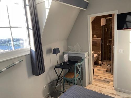 eine Treppe mit einem Schreibtisch in einem Zimmer mit einem Fenster in der Unterkunft Les Fregates in Veulettes-sur-Mer