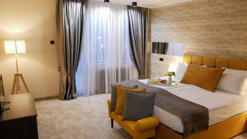 - une chambre avec un grand lit et une chaise jaune dans l'établissement Riverside Boutique Hotel, à Bansko