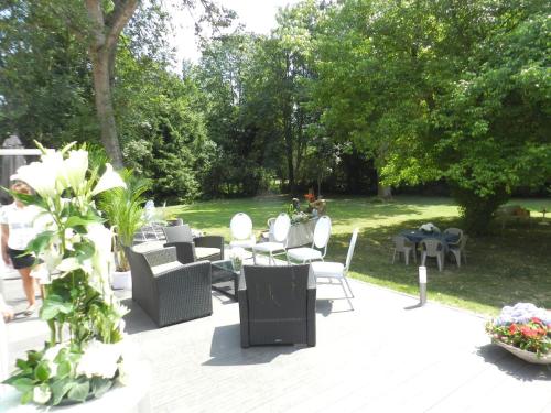 patio z krzesłami i stołami w parku w obiekcie Domaine de la Palle w mieście Pontgibaud