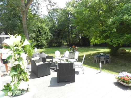 a patio with chairs and tables in a park at Domaine de la Palle in Pontgibaud