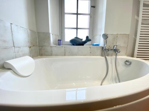 a white bath tub in a bathroom with a window at Domaine Les Mûriers in Brignoles