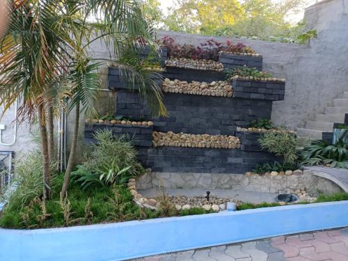 una pared de retención con una escalera en un jardín en Harisuns Plaza, en Attingal